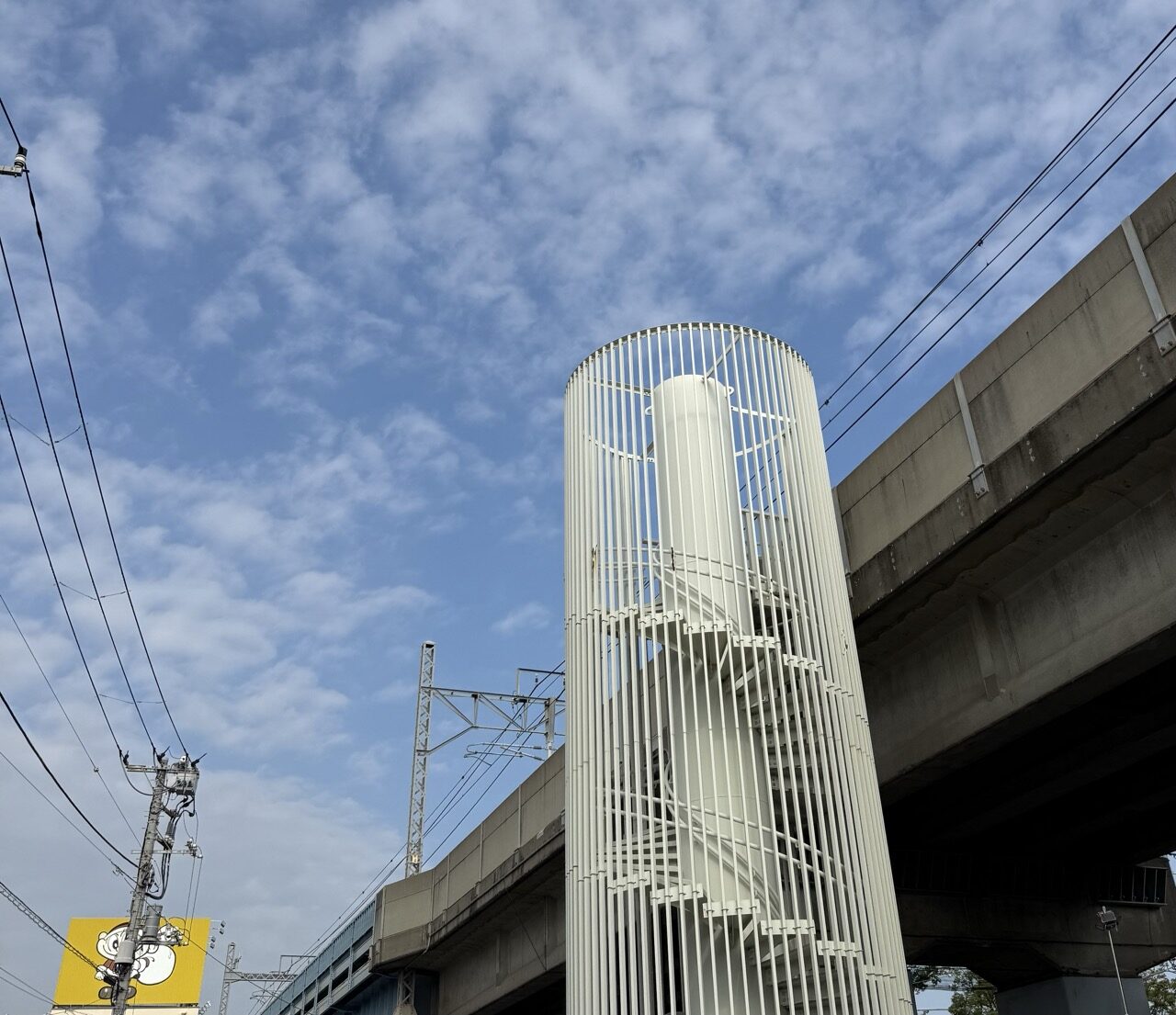 うろこ雲の下、高架脇のらせん階段